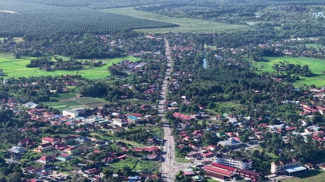 An expansive aerial view showcasing a suburban area with interconnected roads, housing, parks, and green fields at Kubang Semang