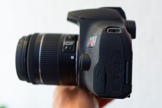 ZAPOPAN, MEXICO - SEPTEMBER 10, 2026: Hand holding a Canon EOS Rebel T8i camera side.