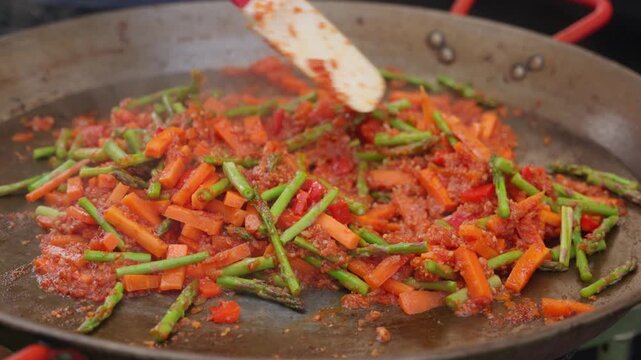 Chef cooking vegetable sofrito for spanish paella