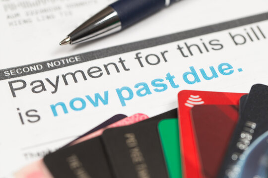 Medical billing statement showing a past due amount, with a pen and credit cards. Highlights financial stress, healthcare costs, insurance adjustments, and overdue payments.