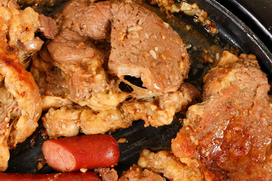 Barbecue featuring golden brown beef and succulent grilled sausage, with tender texture and caramelized fat.