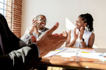 Obraz premium People clapping in a bright office setting, celebrating success.