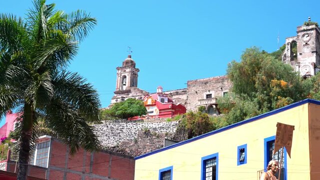 Historic colonial Mexican church and colorful town buildings on a sunny day with clear blue sky