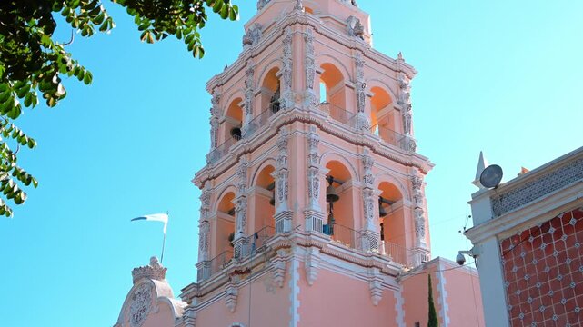 Historic colonial bell tower of a Mexican church against a clear blue sky