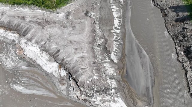 Top-down drone perspective revealing heavy sediment accumulation and washed-out riverbanks along the Parvati River, documenting river basin vulnerability in northern India.