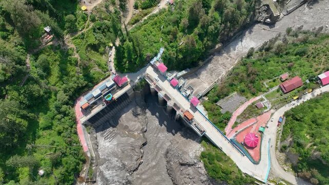 High angle drone shot revealing severe sediment buildup and drying mud patterns in the Barshaini dam reservoir basin, highlighting environmental challenges in Himachal Pradesh.