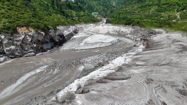 Drone view of a devastated Himalayan riverbed carved by intense flash floods and sediment runoff, documenting river basin vulnerability in northern India.