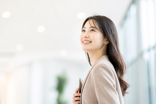 笑顔で上を見上げるビジネスウーマン