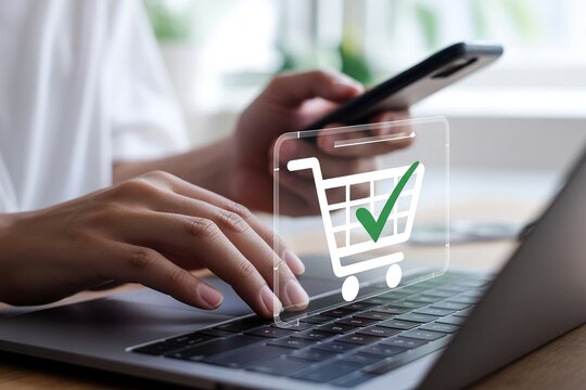 Shopping cart icon with check mark floating over laptop keyboard during mobile transaction.