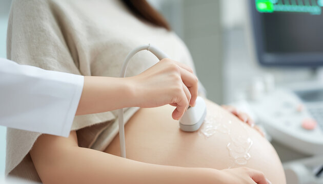 A healthcare professional uses an ultrasound probe on a pregnant woman&rsquo;s abdomen during a prenatal examination.
