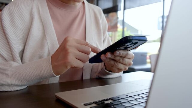 Woman using a smartphone while working. Representing social media, digital technology, remote work and modern business lifestyle.