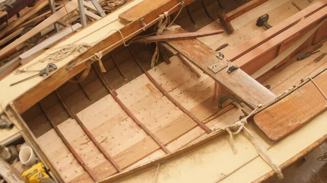Restoring traditional clinker sailboat overhead panning shot