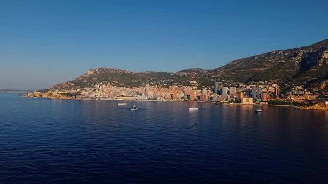 Aerial view of Montecarlo coastline with city buildings and boats at sunset