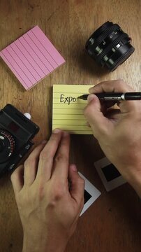 Video of hand with notes about Exposure Triangle in photography Shutter Speed, Aperture and ISO