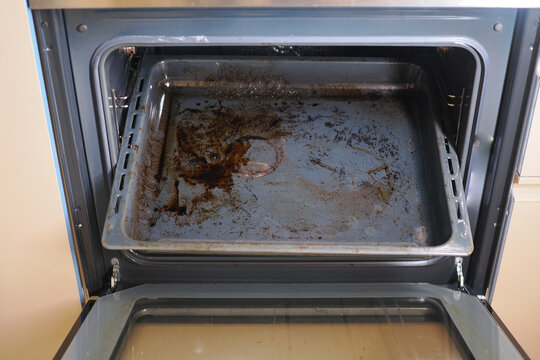 Dirty oven with used baking tray inside