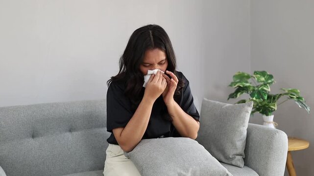 Asian attractive Woman sick with blowing nose sneezing with tissue for infection
