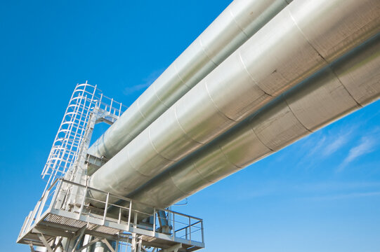 The photo shows a pipeline against a blue sky