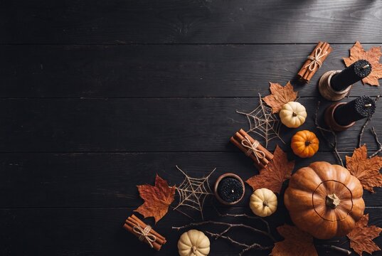 Overhead Halloween still life with carved pumpkin, candles, autumn leaves and rustic decorations for seasonal greeting banner design