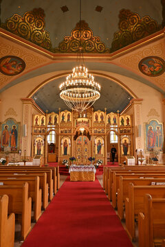 Ornate interior of an Orthodox church with a golden iconostasis, religious icons and altar