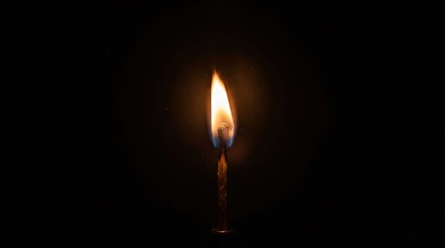 Single burning matchstick with bright flame isolated on black background