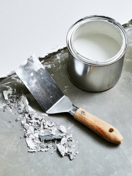 Putty Knife and Paint Can During Home Wall Repair