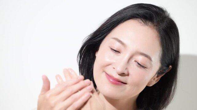 手荒れや冷え性に悩み手を気にする50代女性、冬の乾燥肌や手先や指の冷えを感じるミドル世代の動画