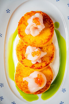 Delightful presentation of savory pancakes topped with fresh seafood and creamy sauce