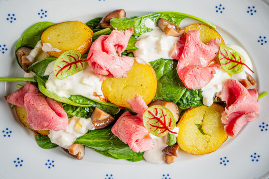 Delightful salad with spinach, roasted potatoes, and tender beef slices