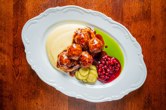 Delicious meatballs served elegantly with creamy mashed potatoes and tangy berry sauce