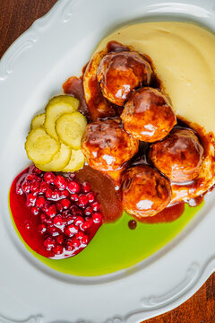 Delicious meatballs served with creamy sauce and vibrant sides in a charming restaurant