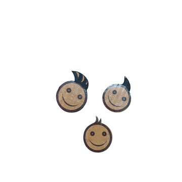 Three circular cardboard cutouts featuring hand-drawn smiling faces with small tufts of hair on arranged on a white background surface isolated on a transparent background