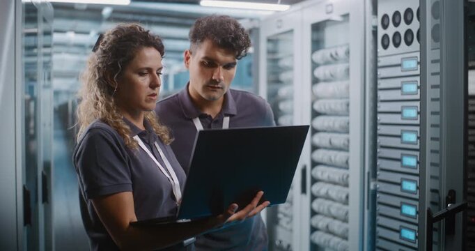 Female IT Specialist and Male Colleague Review System Diagnostics on Laptop Together in Data Center Server Room. Teamwork, Cloud Infrastructure Management Ensure High Availability Server Operations.