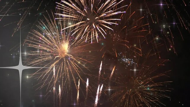Sparkling fireworks exploding in the night sky with white starbursts and colorful sparks flying high