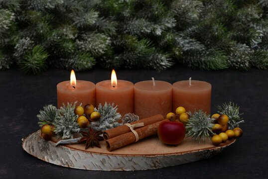 Rustic Advent arrangement with four candles on a wooden tray; two candles are lit for the Second Sunday of Advent.