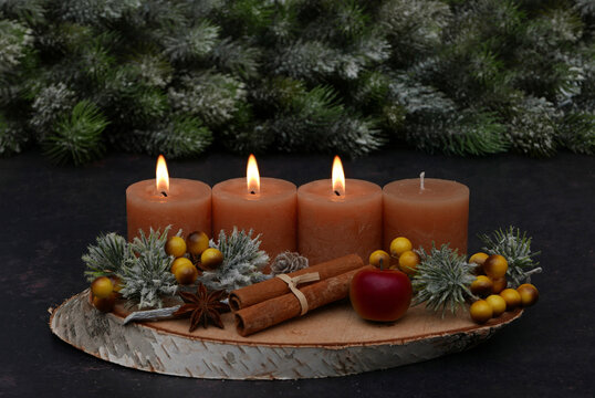 Rustic Advent arrangement with four candles on a wooden tray; three candles are lit for the third Sunday of Advent.