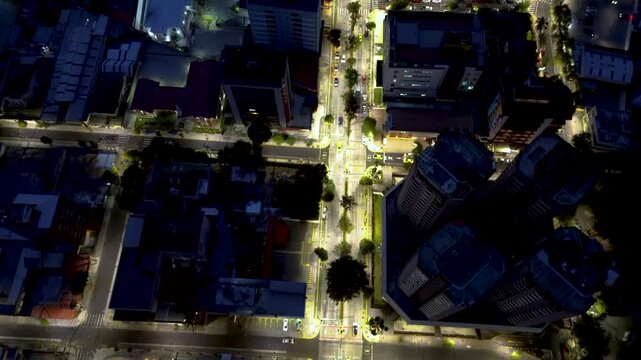 Top Down Night View of Quito Ecuador City Intersection with Bright Street Lights, Traffic, Crosswalks and Urban Building Blocks