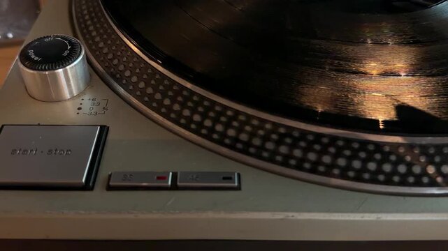 Close-up video of a vinyl record spinning on a turntable in a cafe, illustrating analog music playback and vintage audio technology.