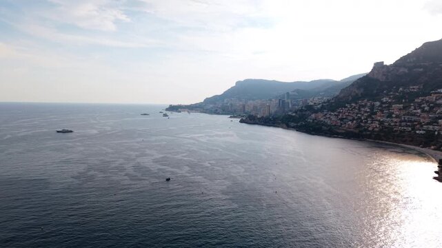 Aerial view of Montecarlo coastline with city buildings and boats on a sunny day