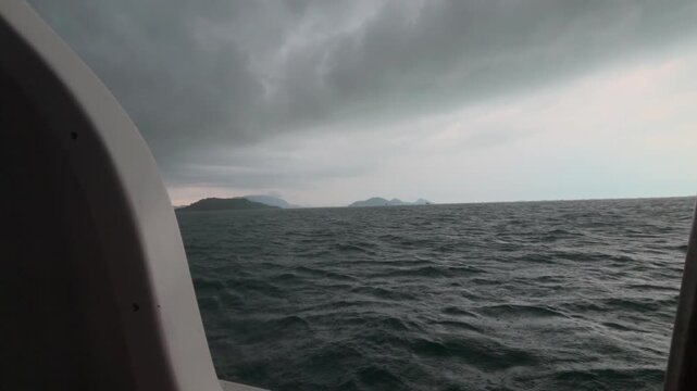 Sideways view from a moving speedboat across choppy open water as waves pass alongside and occasional sea spray splashes across the frame.