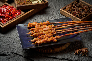 Spicy grilled lamb skewers on dark stone plate © wang