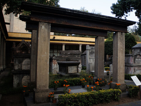 Historic stone mausoleum framed by stone portico decorated with marigolds in San Fernando Cemetery Museum in Mexico City
