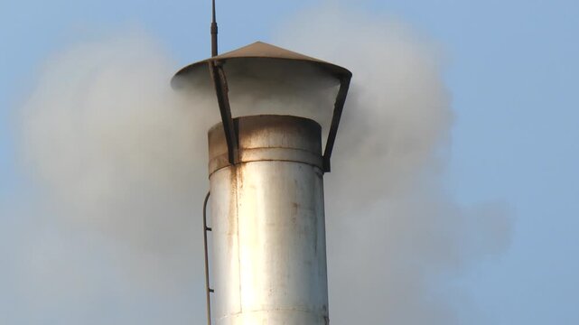 Industrial metal chimney stack emitting white smoke, pollution and environmental exhaust concepts for air quality