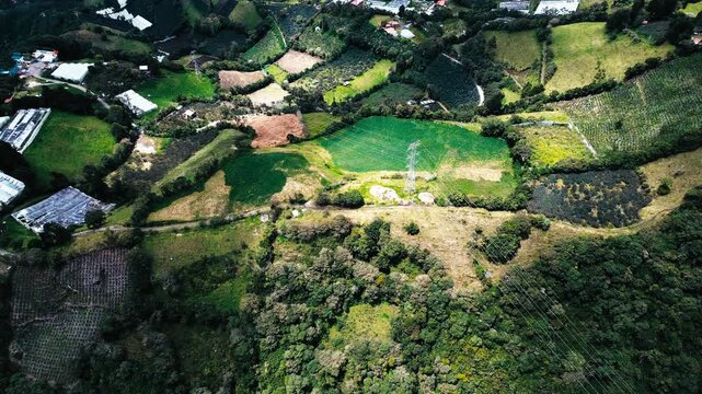 Aerial View of Rural Andean Farmland in Ecuador with Green Fields, Forest Patch, Mountain Slopes and Scenic Countryside Texture