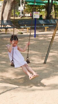 Young Thai Girl in White Dress Playing on Swing at Lumpini Park