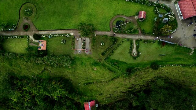 Top Down Drone View of Mountain Lodge Garden in Ecuador with Lawns, Pathways, Flowers and Cloud Forest Tourism Landscape