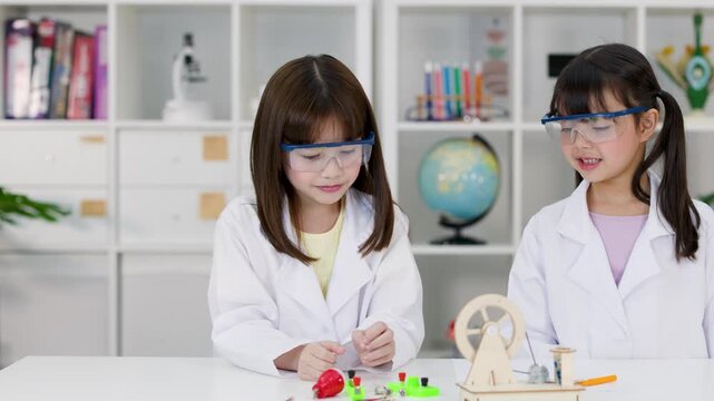 Elementary Students in Lab Coats Conducting Science Experiment in Classroom