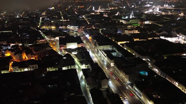 Aerial Night View of Quito Ecuador Downtown Streets with City Lights, Urban Blocks, Historic Buildings and Mountain Capital Atmosphere