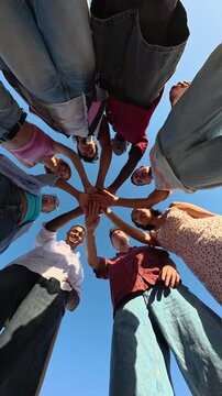 Diverse group of friends stacking hands in unity