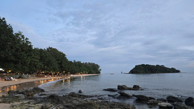 Scenic Tropical Beach Landscape At Twilight With Lush Coastal Trees And Distant Island Views