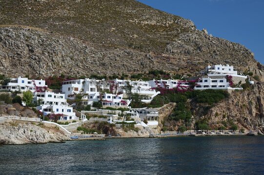 Whitewashed houses arranged on a hill along a rocky coast, Zero Waste Island, Livadia, Tilos, Dodecanese, Greek Islands, Greece